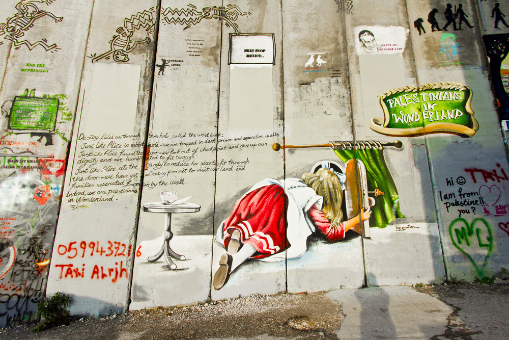 壁の向こうが見える窓を覗く少女