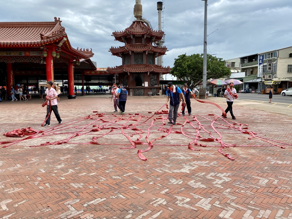 廟の前庭に爆竹を敷く人達
